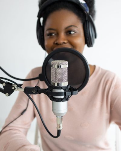 woman smiling while in front of microphone